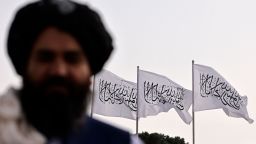 A Taliban fighter is pictured against the backdrop of Taliban flags installed at the Hamid Karzai International Airport in Kabul on September 11, 2021. (Photo by Karim SAHIB / AFP) (Photo by KARIM SAHIB/AFP via Getty Images)