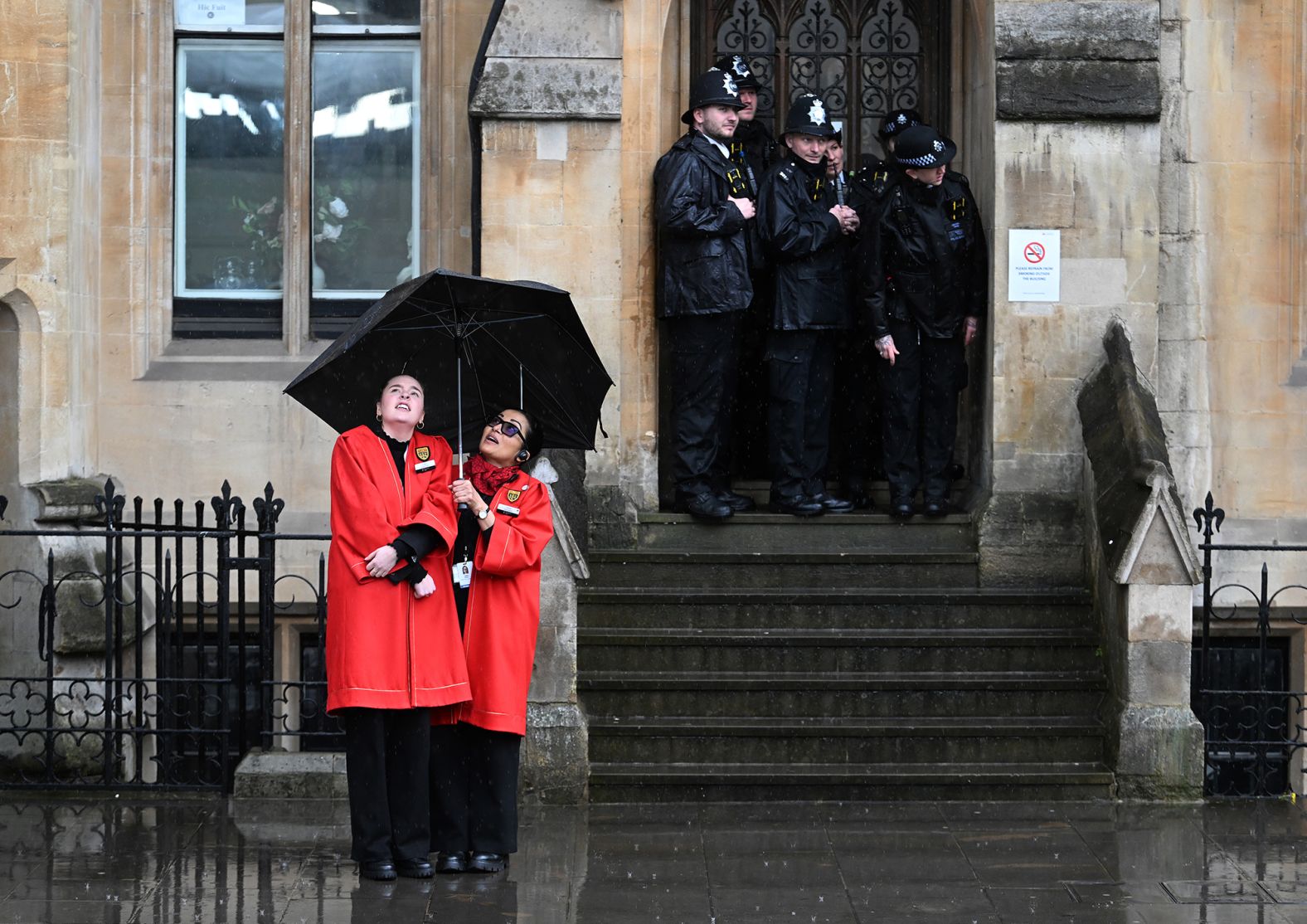 Westminster staff and police take cover from the rain on Friday.