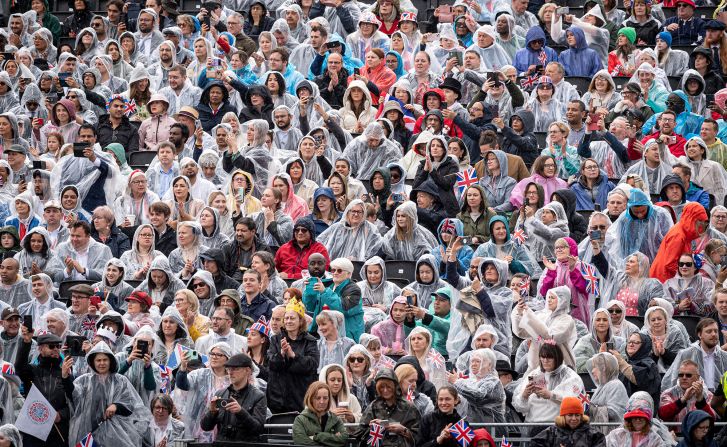 People gather to watch the procession. Showers moved through London on Friday and <a href="https://www.cnn.com/uk/live-news/king-charles-iii-coronation-ckc-intl-gbr/h_0cf74794c8e0be8ca222db150c2ccb94" target="_blank">more rain was expected for Saturday</a>.