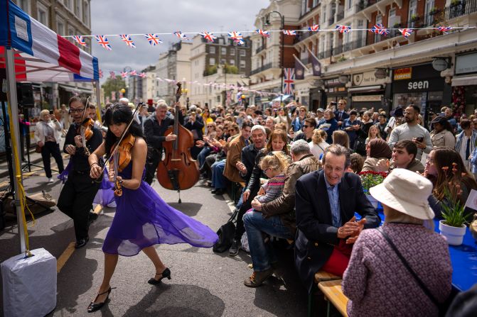 Musicians play while people take part in the "Coronation Big Lunch" in London on Sunday. Thousands of community events took place across the country to <a href="http://www.cnn.com/2023/05/06/uk/gallery/coronation-celebrations/index.html" target="_blank">commemorate the King's coronation</a>.