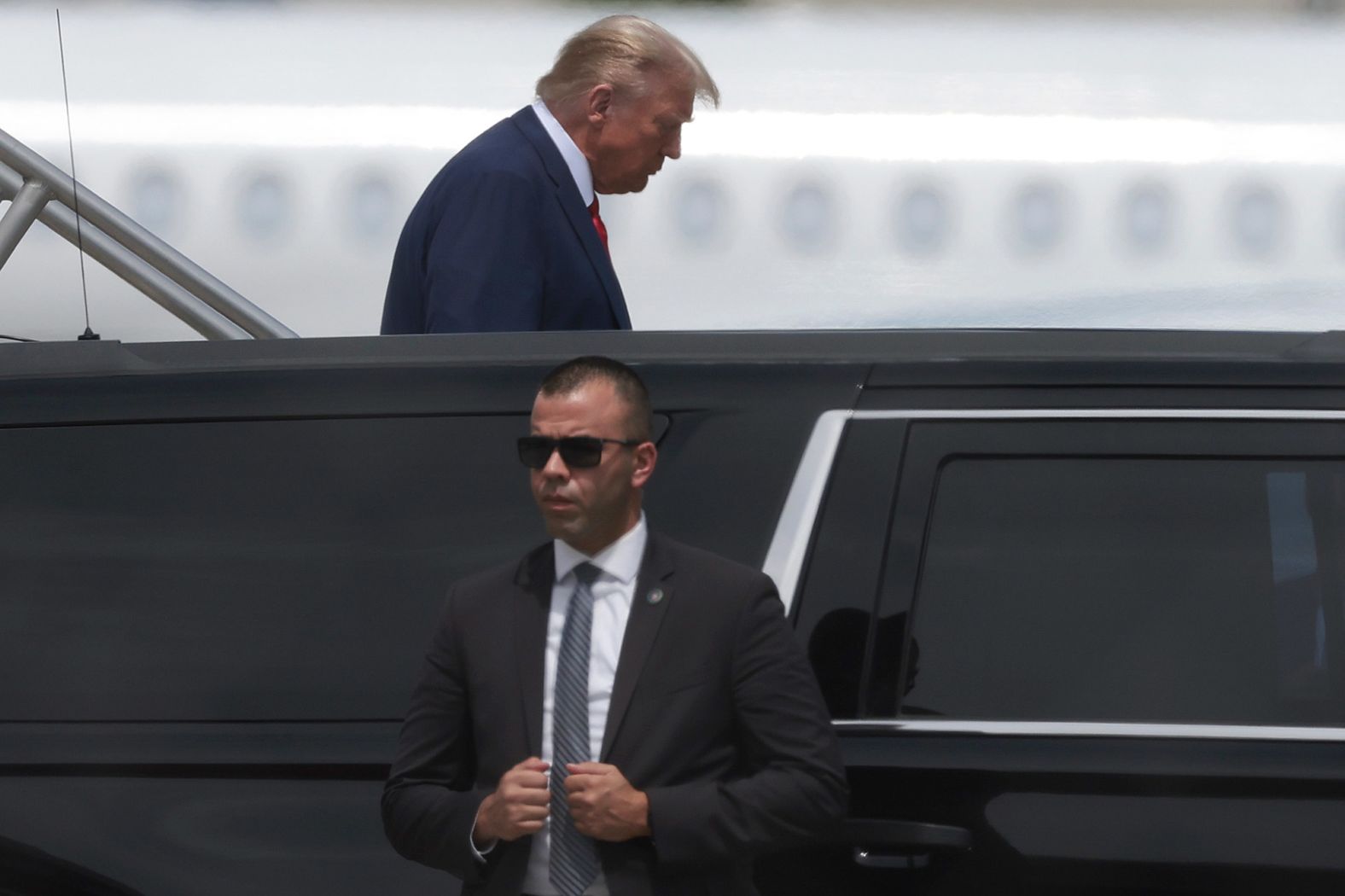 Trump walks down steps after his plane arrived in Miami.