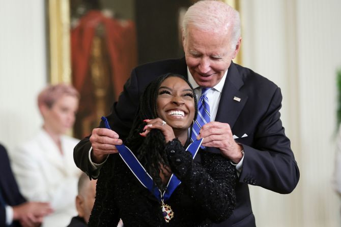 President Joe Biden awards Biles with the Presidential Medal of Freedom in July 2022. Biles, 25, became <a href="https://www.cnn.com/2022/07/07/politics/biden-presidential-medal-of-freedom/index.html" target="_blank">the youngest person ever to receive the award</a>. "When she stands on the podium,we see what she is: absolute courage to turn personal pain into a greater purpose, to stand and speak up for those who cannot speak for themselves," Biden said.