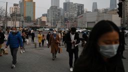 People walk on a street at the end of the workday in Beijing on March 17, 2023. (Photo by GREG BAKER / AFP) (Photo by GREG BAKER/AFP via Getty Images)