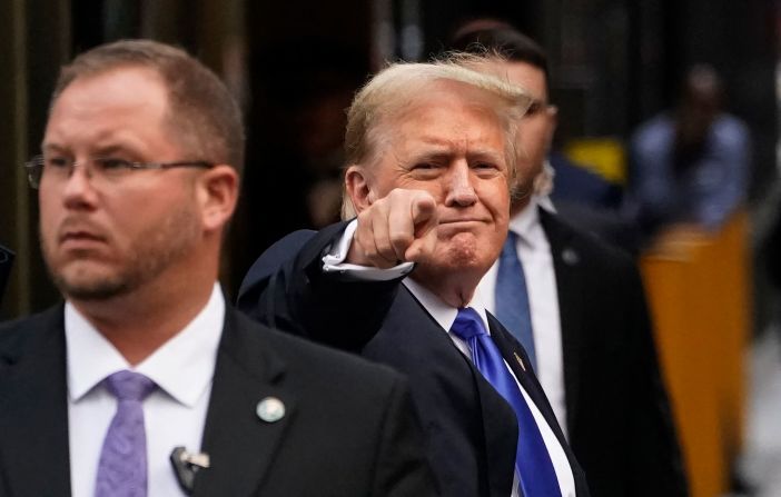 Trump points as he arrives back at Trump Tower in New York after his conviction.