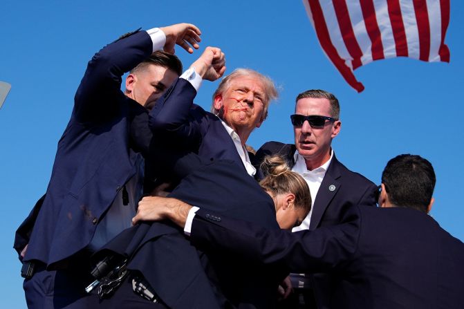 Trump, with blood on his face, raises his fist to the crowd as he is surrounded by Secret Service agents at a campaign rally in Butler, Pennsylvania, in July 2024. <a href="https://www.cnn.com/2024/07/13/politics/trump-injured-pennsylvania-rally/index.html" target="_blank">Trump was injured</a> in a shooting that the FBI said was an assassination attempt.