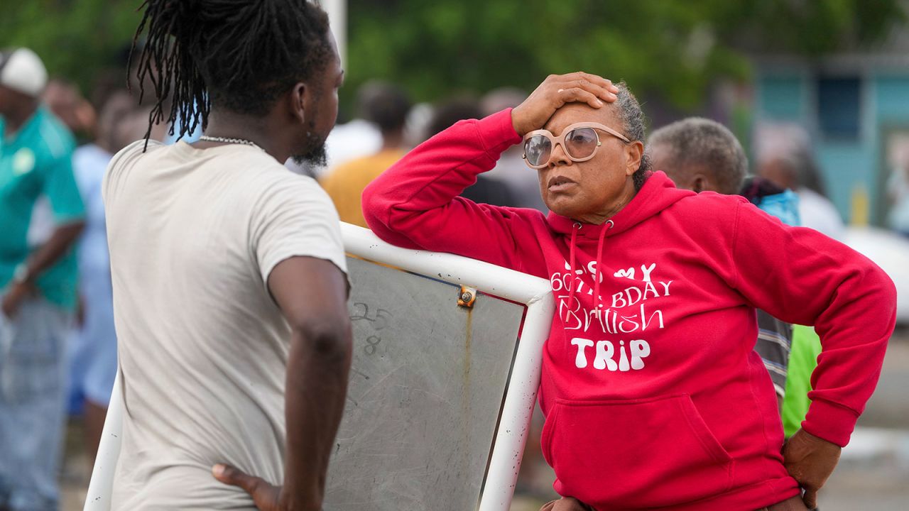 Sylvia Small, right, waits for police approval to enter the pier to check her boat's damages due to Hurricane Beryl at the Bridgetown Fisheries in Barbados on Monday.