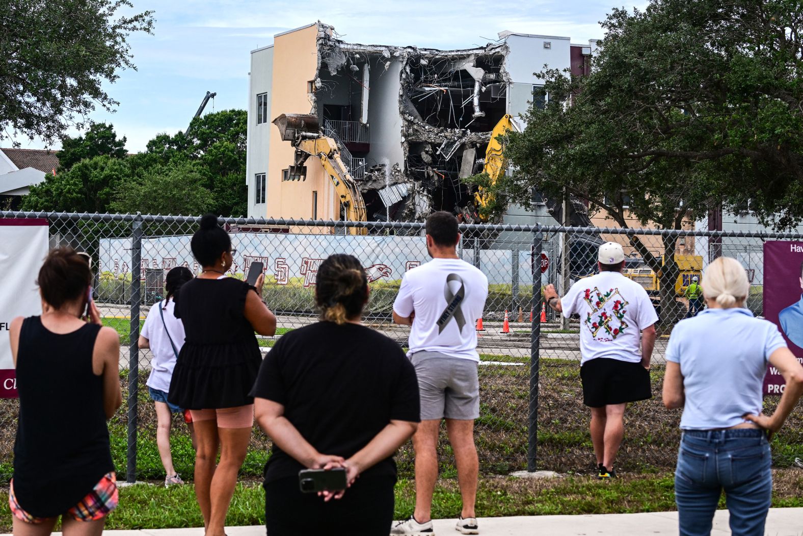 People watch on Friday, June 14, as crews begin to <a href="https://www.cnn.com/2024/06/14/us/parkland-demolish-stoneman-douglas-high-school-shooting/index.html">demolish the building</a> where 17 people were killed during the 2018 mass shooting at Marjory Stoneman Douglas High School in Parkland, Florida.