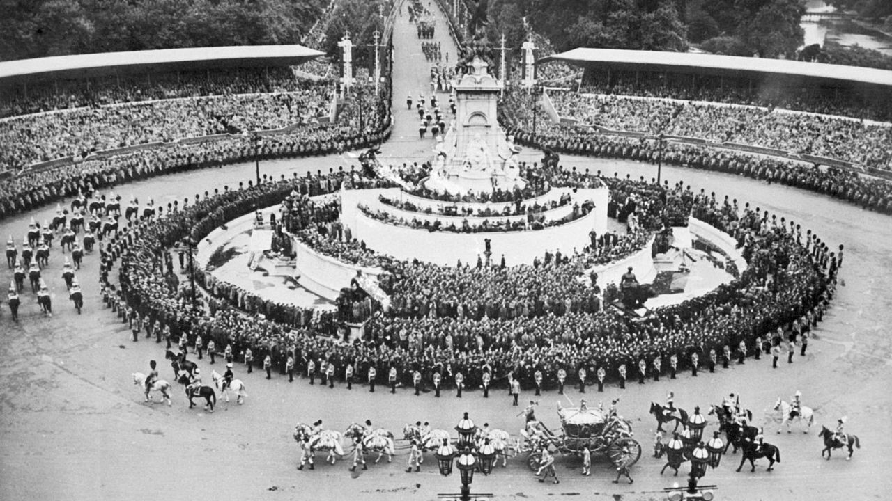 The Queen's carriage passes by the Victoria Memorial in front of Buckingham Palace.