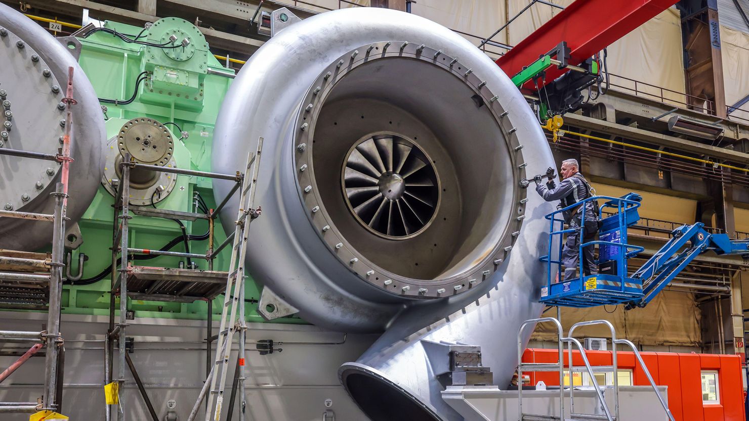 An industrial mechanic works on a gear at MAN Energy Solutions in Augsburg, Germany.