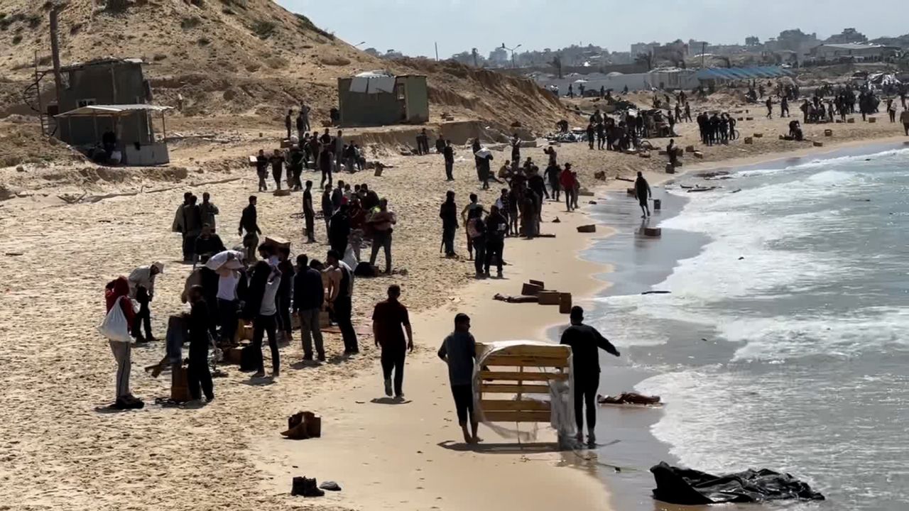 People gather on the beach in Beit Lahia as they collect aid in Gaza, on March 26.