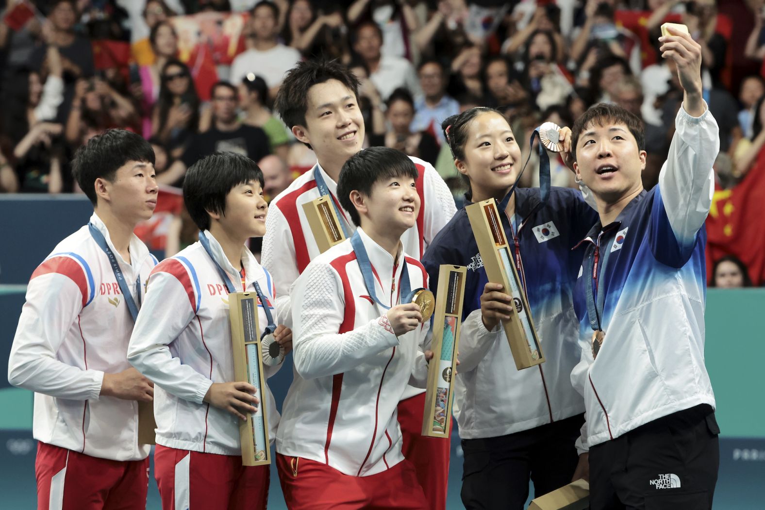 South Korean table tennis player Lim Jong-hoon <a href="https://www.cnn.com/2024/07/31/sport/north-south-korea-selfie-paris-olympics-spt/index.html">takes a selfie on the medal podium</a> with his mixed-doubles partner, Shin Yu-bin, and teams from China and North Korea on Tuesday, July 30. Lim and Shin won bronze. On the left is the North Korean team of Ri Jong-sik and Kim Kum-yong, who won the silver. At center is the Chinese team of Wang Chuqin and Sun Yingsha, who won the gold.