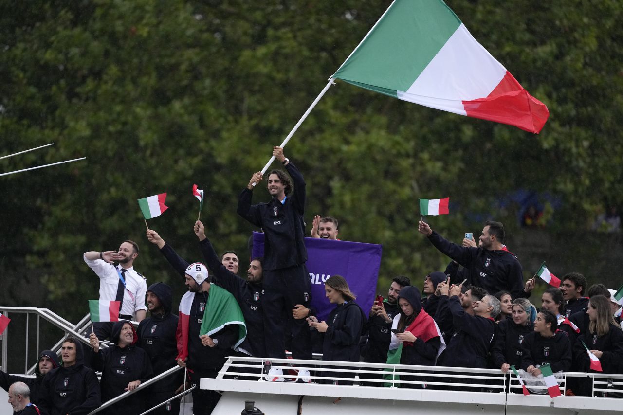 Gianmarco Tamberi waves an Italian flag as the Italian team parades along the Seine river in Paris, France, during the opening ceremony of the 2024 Summer Olympics, on July 26.