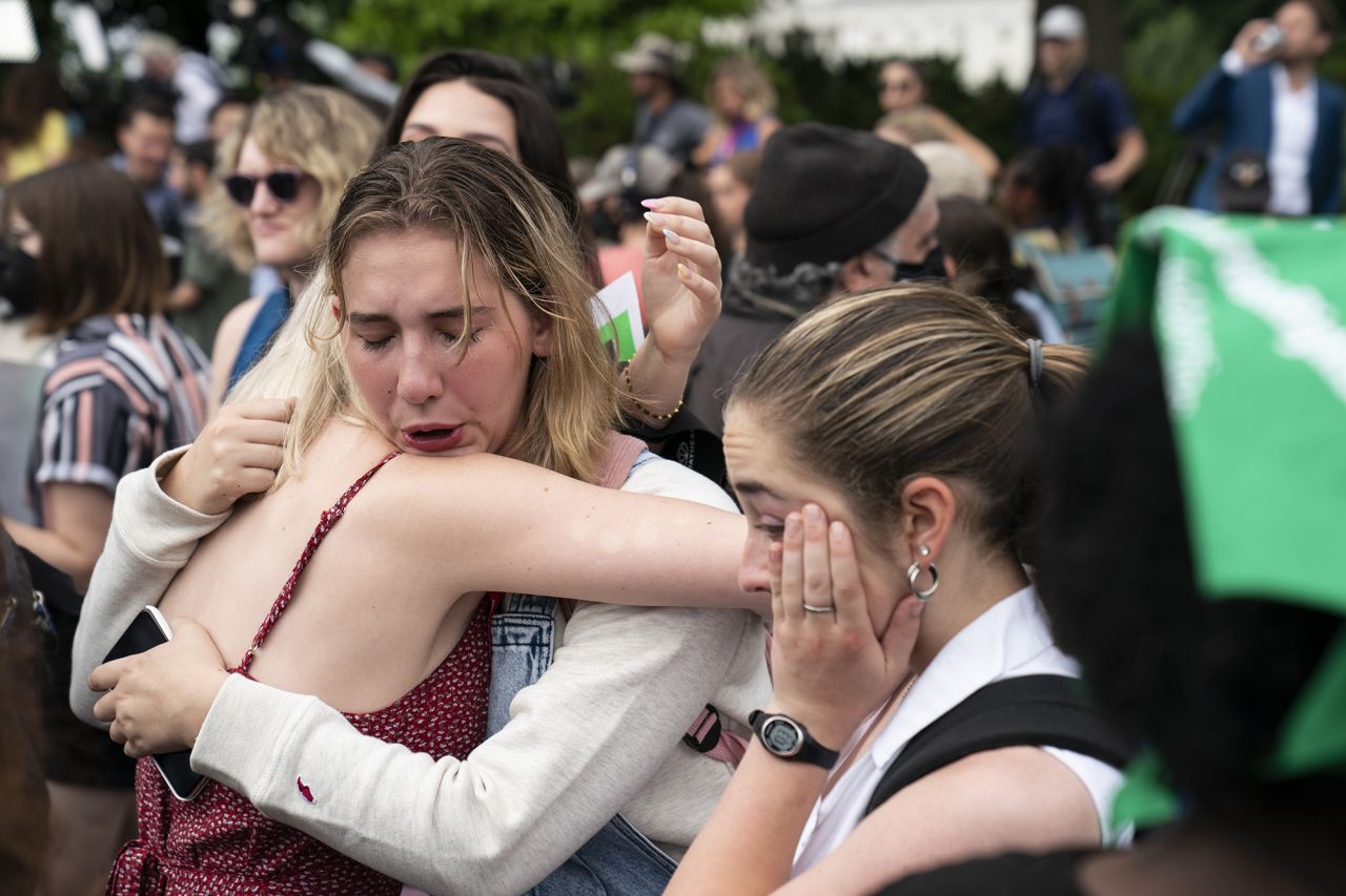 Abortion rights advocates hug outside the Supreme Court on Friday.