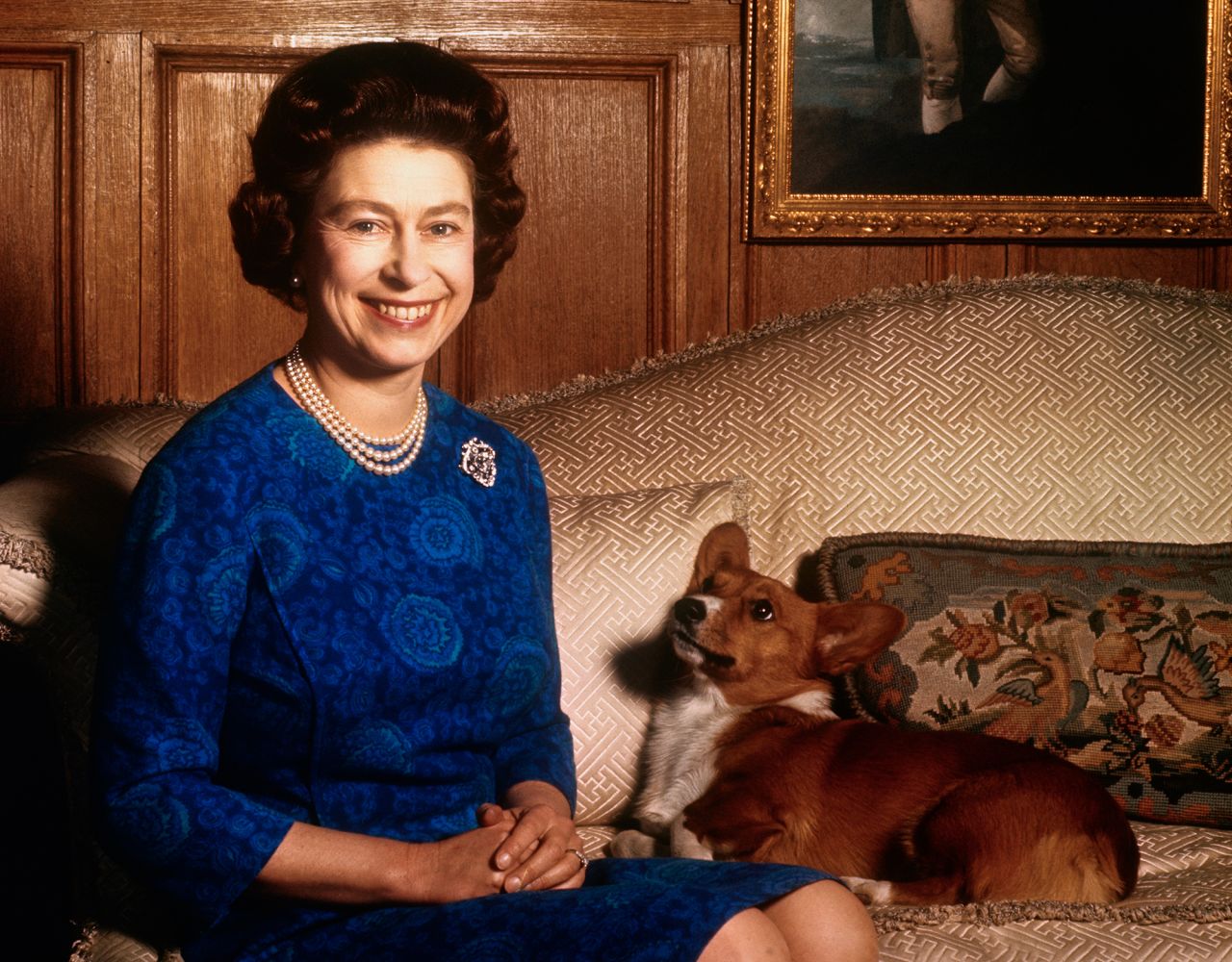 Queen Elizabeth II sits alongside one of her corgis in 1970. 