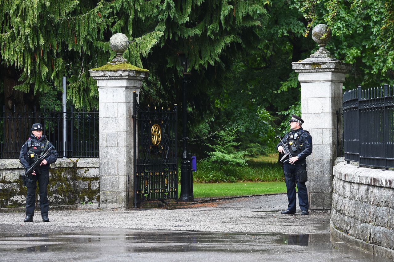 Armed police stand guard outside the gates of the Balmoral Estate in Ballater, Scotland, on Thursday.