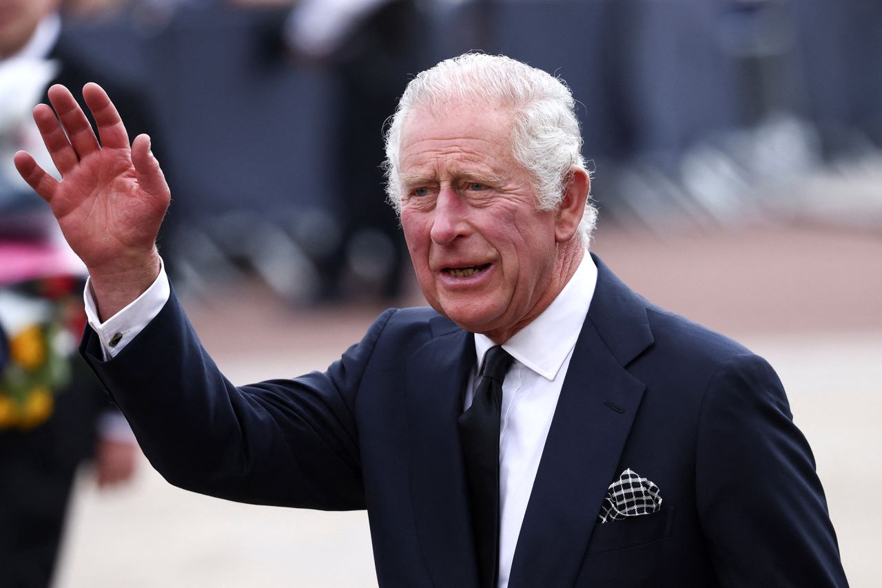 King Charles III waves outside Buckingham Palace, on September 9.