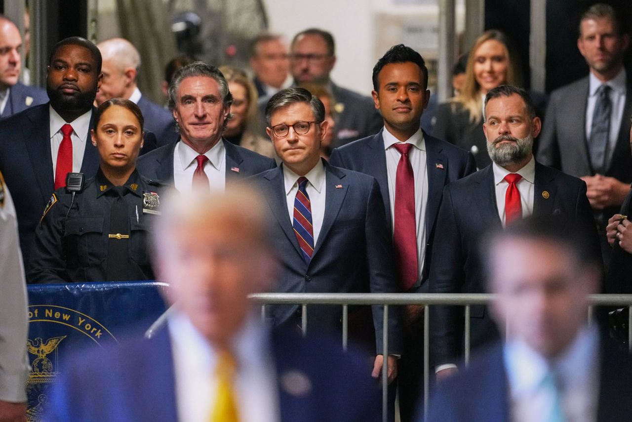 House Speaker Mike Johnson listens as former President Donald Trump speaks to reporters as he arrives to attend his trial for allegedly covering up hush money payments linked to extramarital affairs, at Manhattan Criminal Court in New York City, on May 14. 