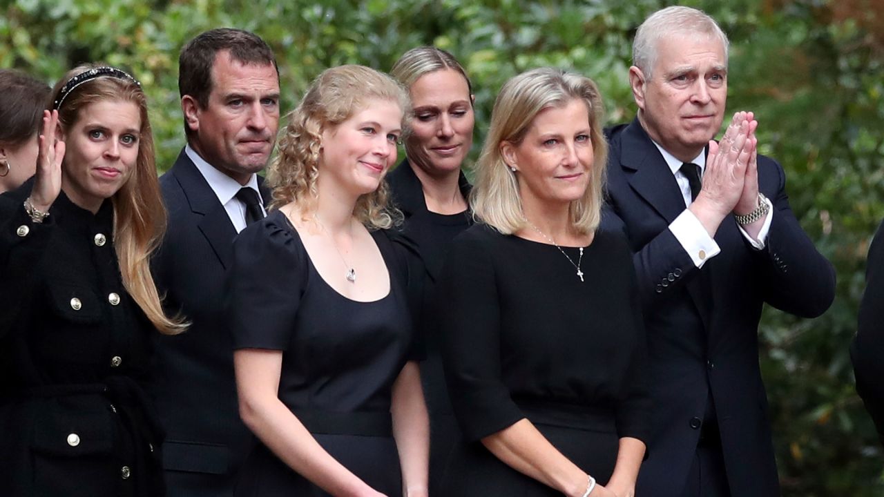 Prince Andrew, right, gestures to the public as members of the royal family look at the floral tributes outside the gates of Scotland's Balmoral Castle on Saturday.