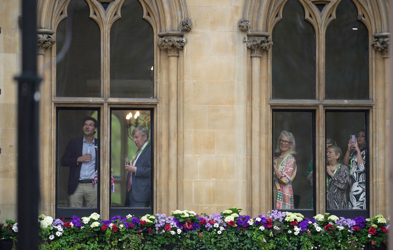 Guests watch the arrival of others for the coronation of King Charles III and Queen Camilla.