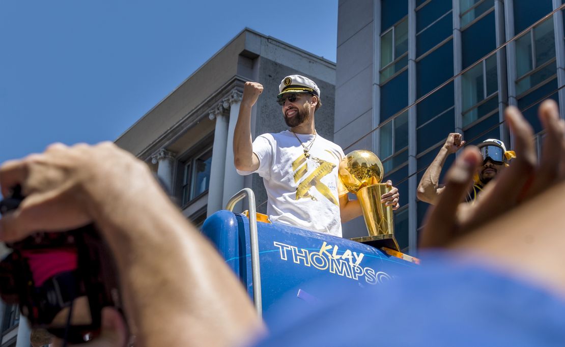 Thompson celebrates with the Larry O'Brien trophy during the Warriors' NBA Championship parade in 2022.