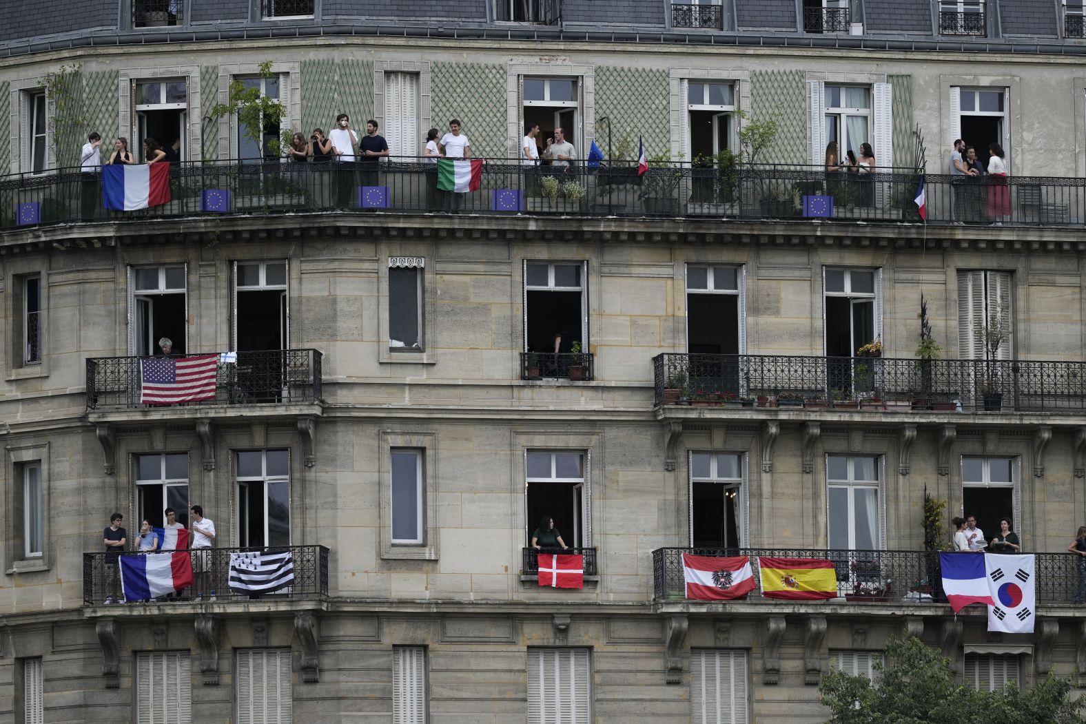 People stand on balconies in Paris to watch the ceremony.