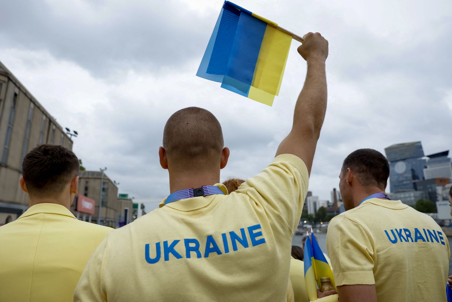 Ukrainian athletes stand on a boat ahead of the Parade of Nations.