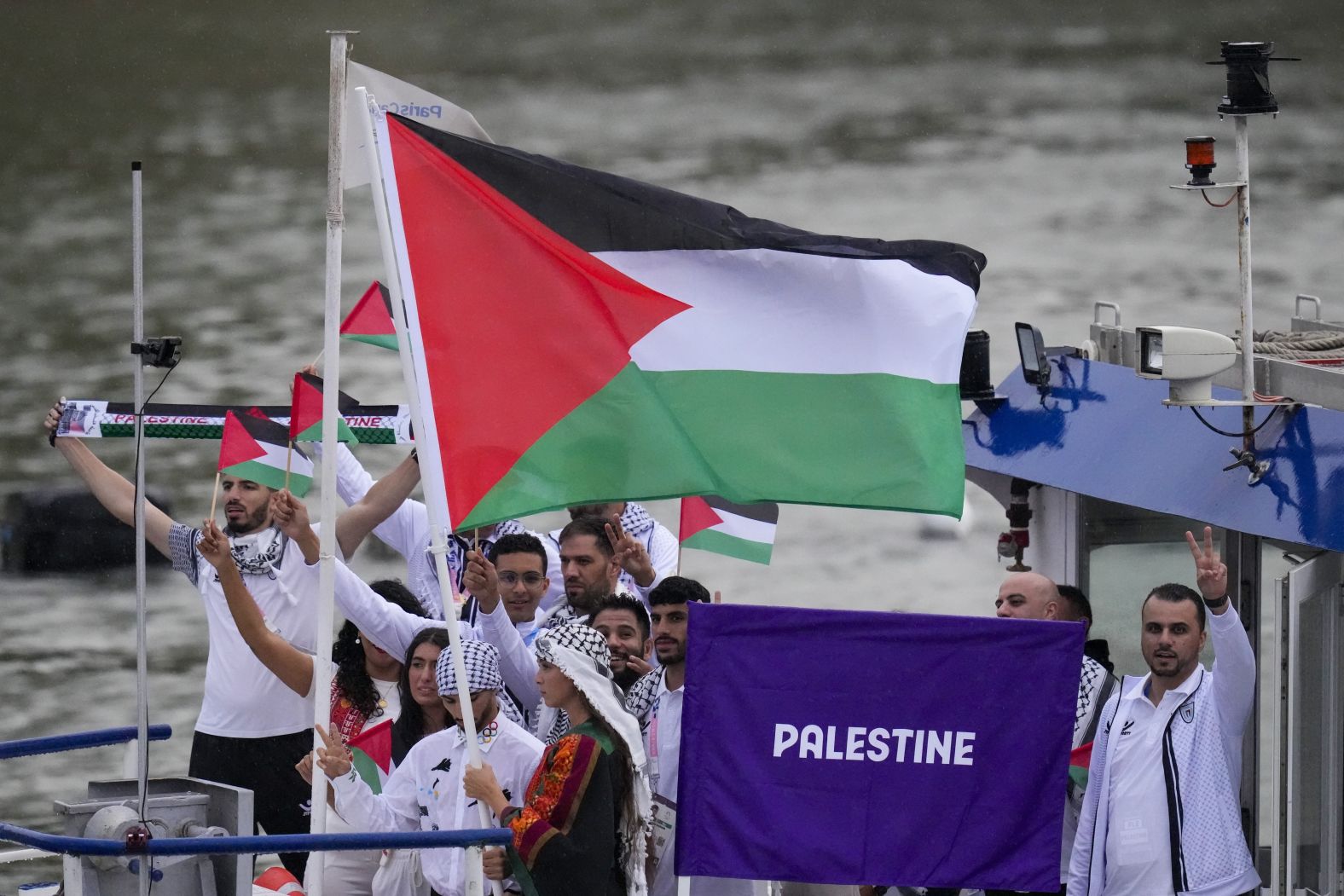 Palestinian athletes wave flags during the Parade of Nations.