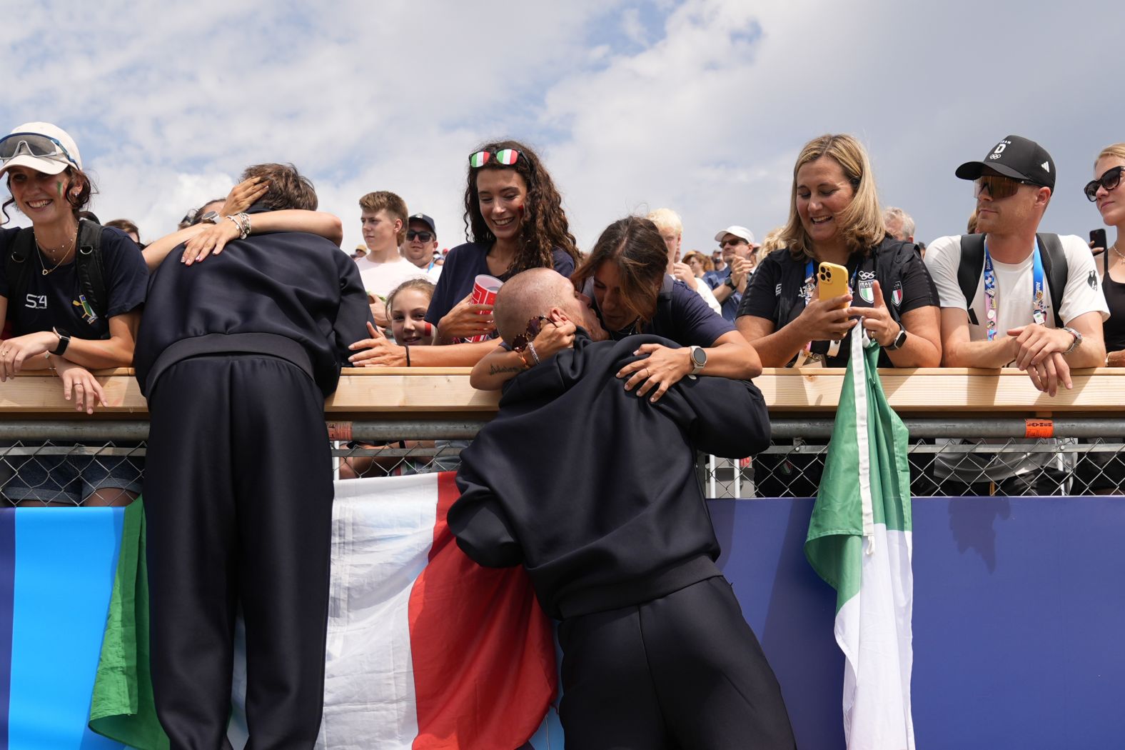 Italian rower Luca Rambaldi, center, celebrates after winning silver in the quadruple sculls on July 31.