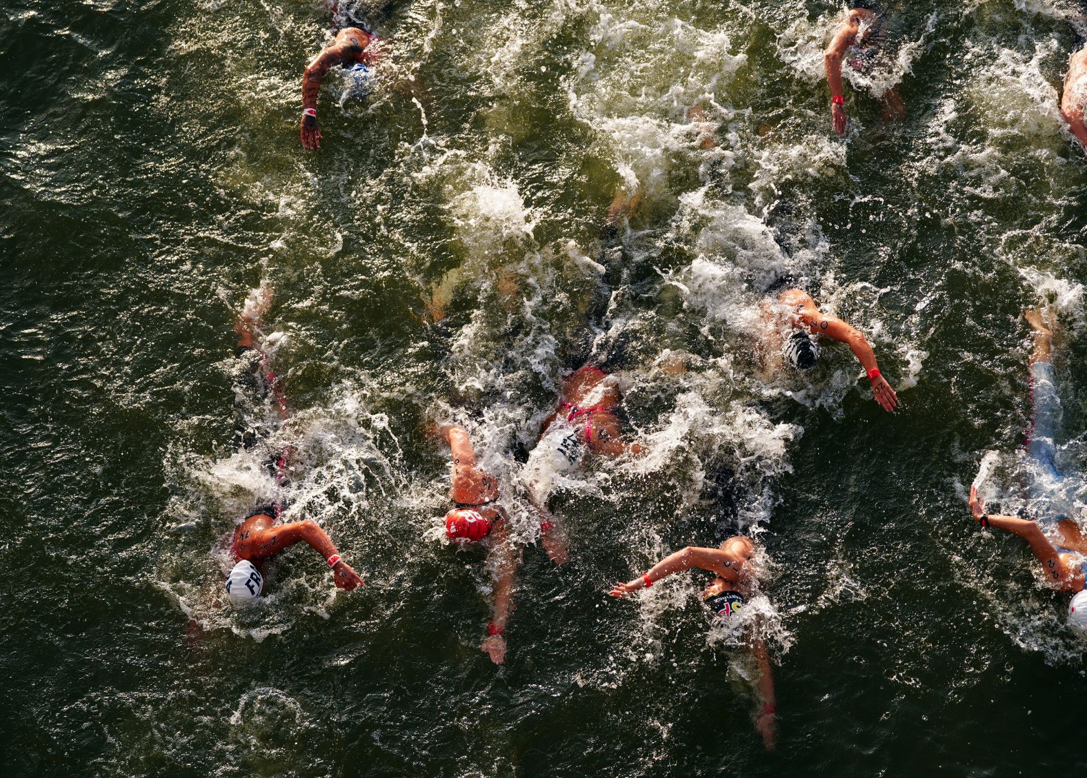 Competitors swim in the Seine River during the women's 10-kilometer marathon on August 8. The water quality of the river has been an <a href="https://cnn.com/2024/08/07/sport/claire-michel-belgian-triathlete-ill-ecoli-spt/index.html">ongoing saga</a> at the Games, but organizers deemed it fit for athletes to race in.