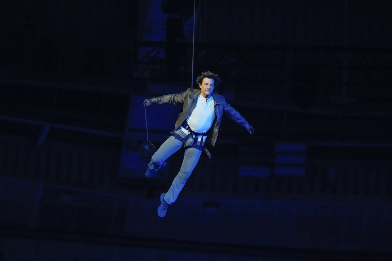 Actor Tom Cruise is lowered onto the floor of the Stade de France after jumping off the stadium's roof during the closing ceremony. He took the Olympic flag from Los Angeles Mayor Karen Bass and rode off on a motorcycle.