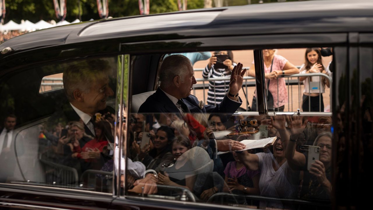 King Charles III greets supporters as he arrives at Buckingham Palace on Saturday.