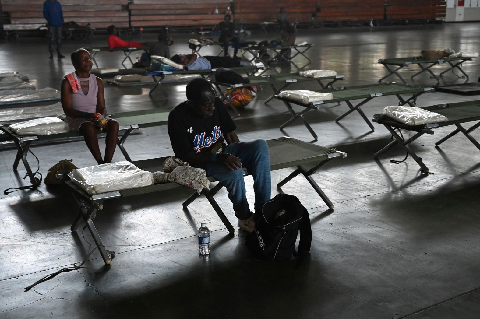 People sit on cots at the National Arena in Kingston, Jamaica, which was serving as a shelter in the aftermath of Hurricane Beryl on Thursday, July 4.