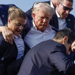 BUTLER, PENNSYLVANIA - JULY 13: Republican presidential candidate former President Donald Trump is rushed offstage by U.S. Secret Service agents after being grazed by a bullet during a rally on July 13, 2024 in Butler, Pennsylvania. Butler County district attorney Richard Goldinger said the shooter is dead after injuring former U.S. President Donald Trump, killing one audience member and injuring another in the shooting. (Photo by Anna Moneymaker/Getty Images)