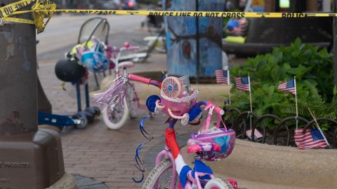 Police crime tape is seen around the area where children's bicycles and baby strollers stand near the scene of the Fourth of July parade shooting that killed seven people in Highland Park, Illinois on July 4, 2022.
