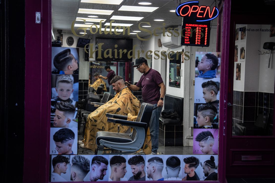 A man gets his hair cut in a barber shop in Colchester, United Kingdom.