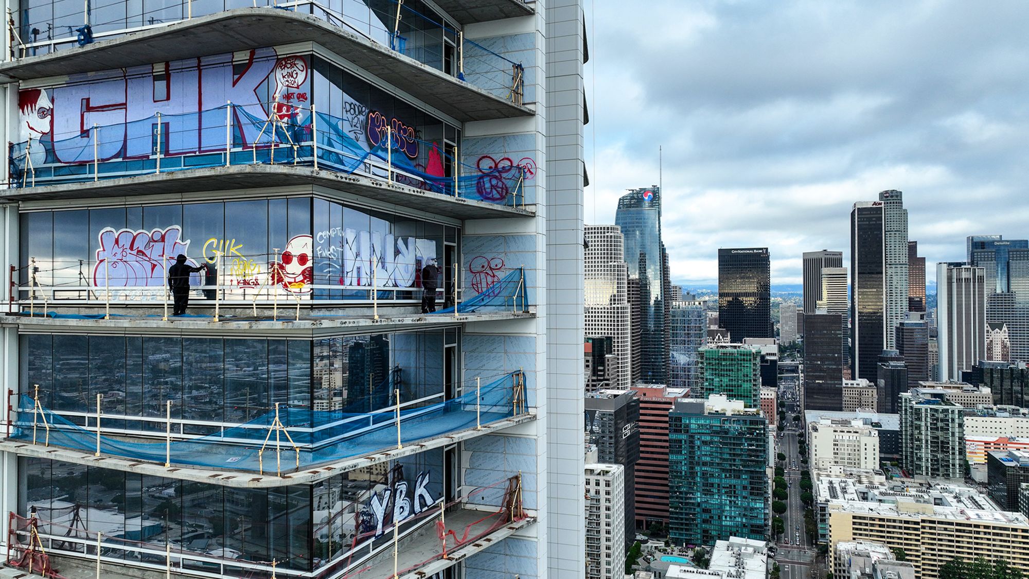 Graffiti artists tag the exterior windows of a high-rise building, part of the abandoned Oceanwide Plaza complex in downtown Los Angeles, on February 1.