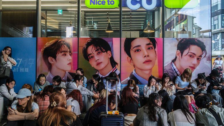 Fans queue up to buy the new album '17 is Right Here', by South Korean boy band Seventeen (or SVT), outside a convenience store in the trendy Hongdae neighbourhood of Seoul on April 29, 2024, on the day of the album's official release.