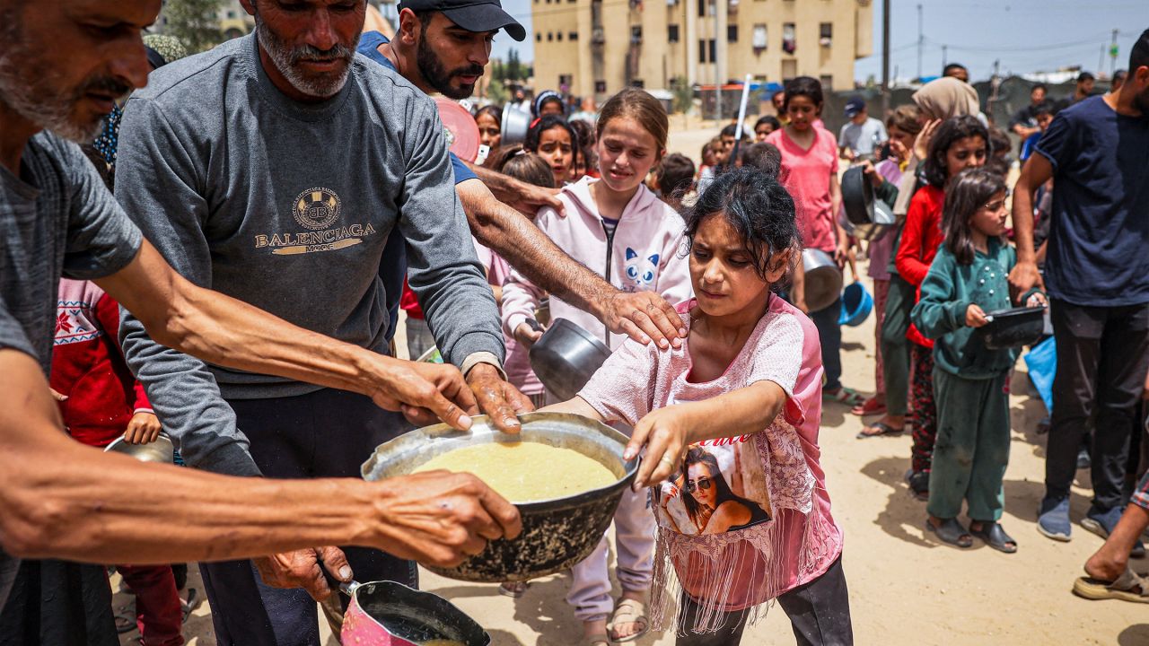 Displaced Palestinian children line up to receive food in Rafah, on the southern Gaza Strip, on May 19, 2024.