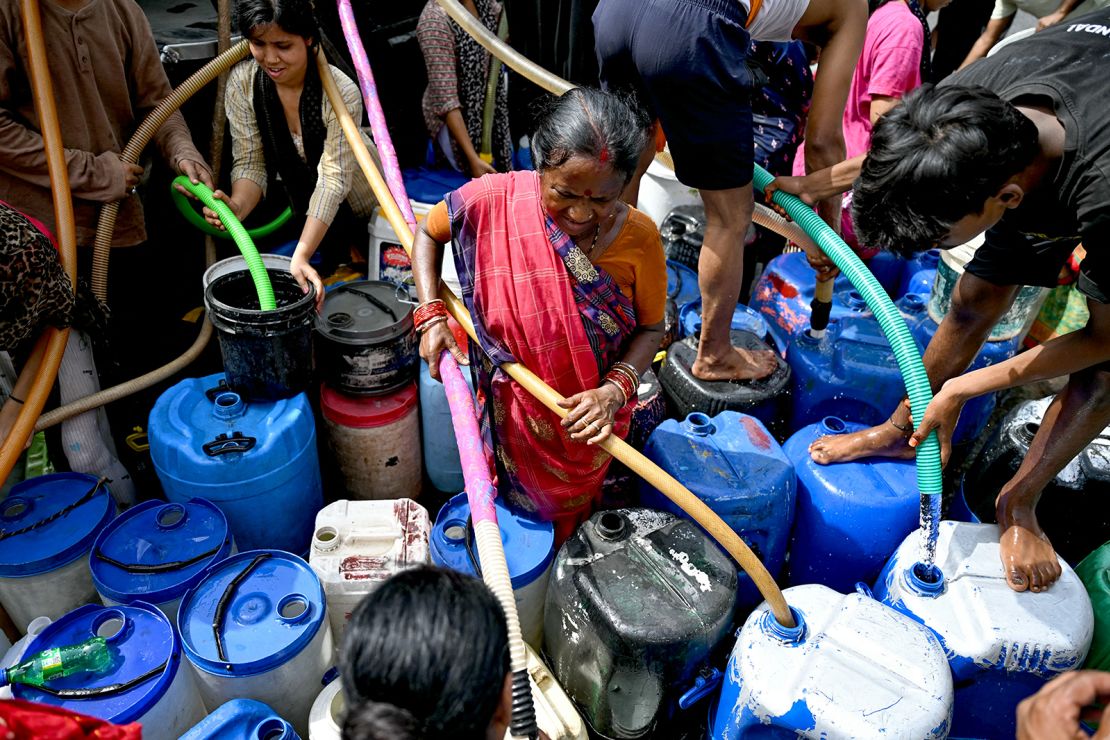 Residents fill their containers with water supplied by a municipal tanker in New Delhi on 19 June, 2024.