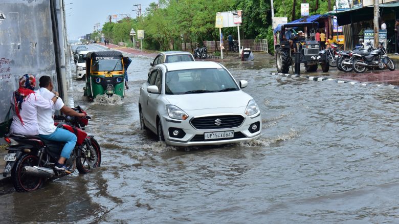 GHAZIABAD, INDIA - JUNE 29: Commuters wade through a waterlogged road during monsoon rainfall at wave city NH9 on June 29, 2024 in Ghaziabad, India. The India Meteorological Department (IMD) predicts heavy to very heavy rainfall in Delhi over the next two days following the city's highest single-day downpour in 88 years on Friday. An 'orange alert' has been issued for Sunday and Monday due to the expected heavy rainfall. (Photo by Sakib Ali/Hindustan Times via Getty Images)
