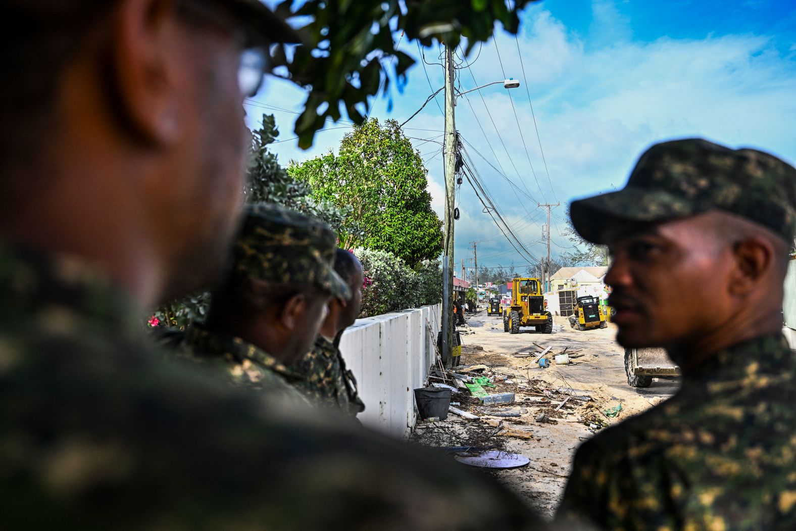 Members of Barbados' armed forces clear a street of sand Monday in Oistins, Barbados.