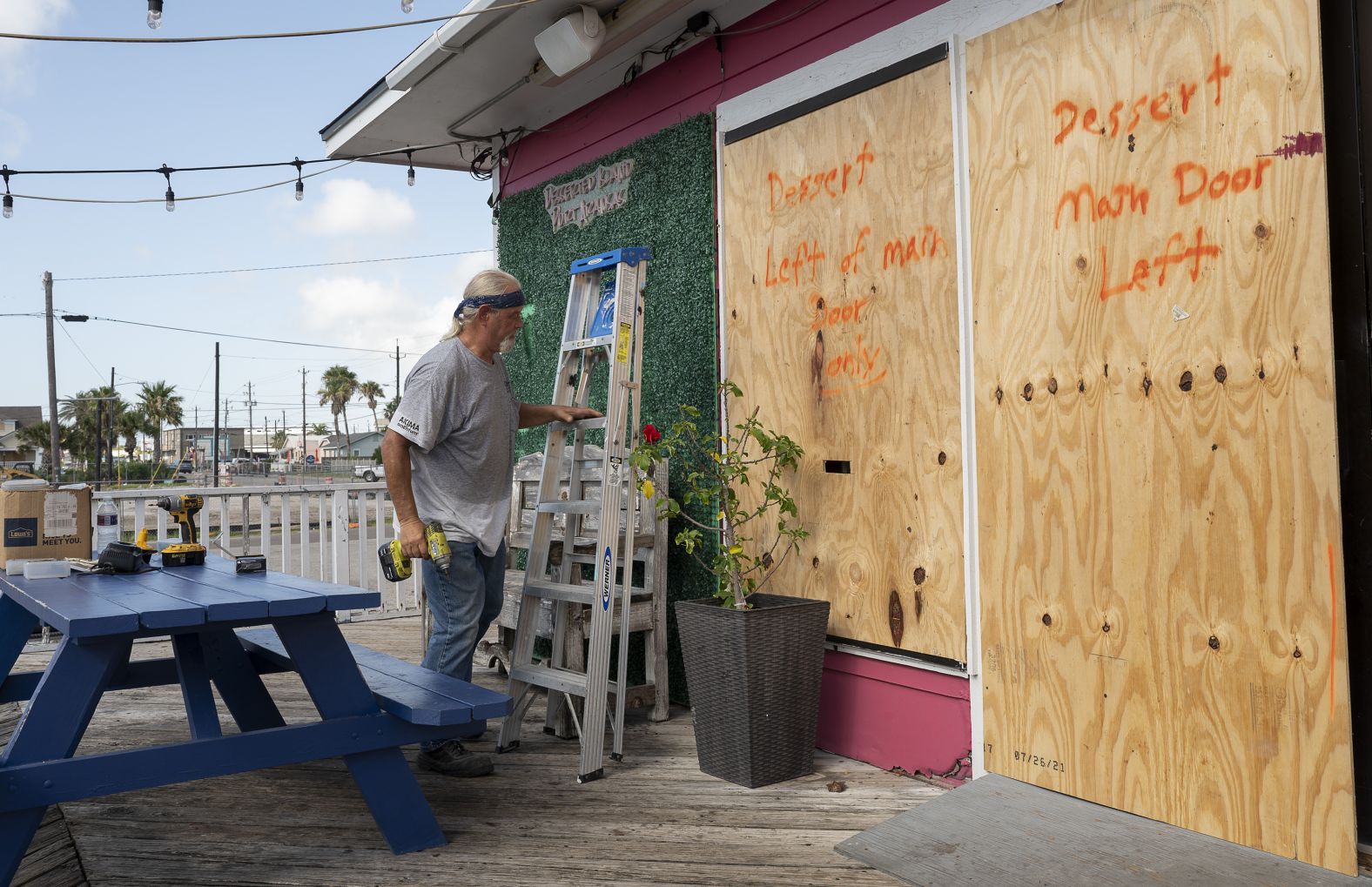 A worker boards up windows at an ice cream parlor in Port Aransas, Texas, on Saturday.