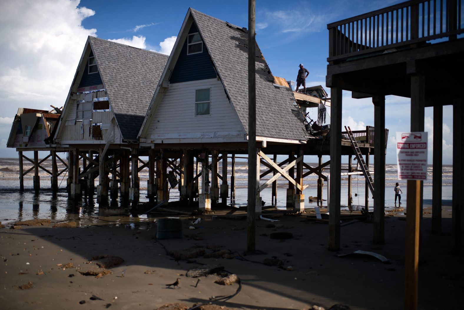 A man surveys a damaged home in Surfside Beach, Texas, on Monday, July 8.