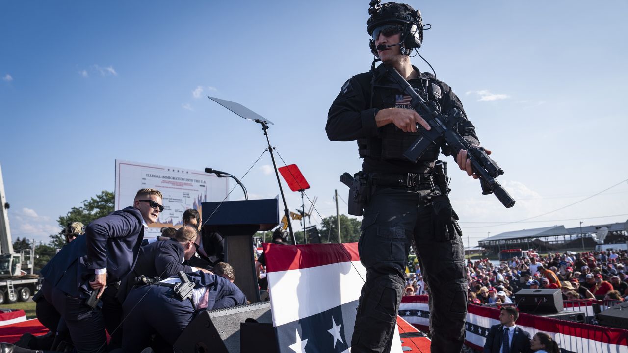 Butler, PA - July 13 : U.S. Secret Service agents and counter assault team react moments after shots were fired toward Republican presidential candidate former president Donald Trump during a campaign rally at Butler Farm Show Inc. in Butler, PA on Saturday, July 13, 2024. Trump later shared that a bullet pierced part of his ear during the assassination attempt. (Photo by Jabin Botsford/The Washington Post via Getty Images)