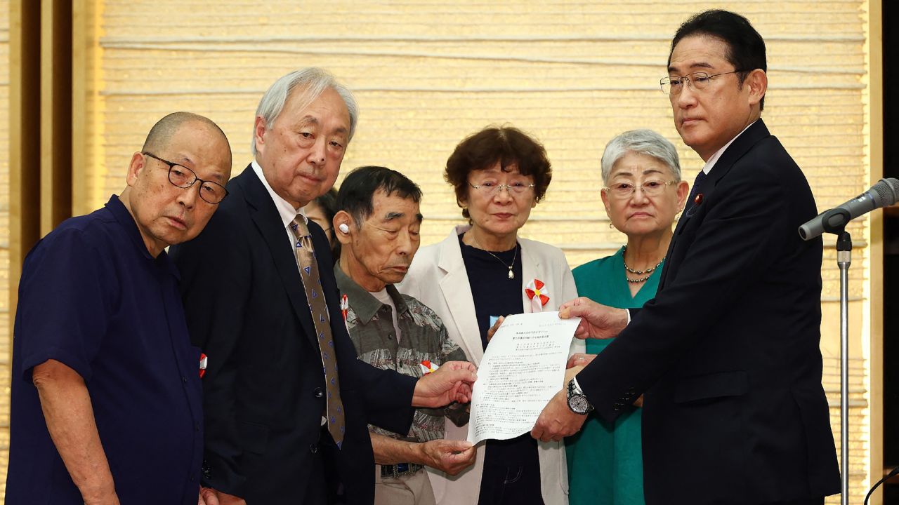 Japan's Prime Minister Fumio Kishida (R) receives a demand letter from the plaintiffs in the forced sterilization lawsuit at the prime minister's office in Tokyo on July 17, 2024. (Photo by JIJI Press / AFP) / Japan OUT (Photo by STR/JIJI Press/AFP via Getty Images)