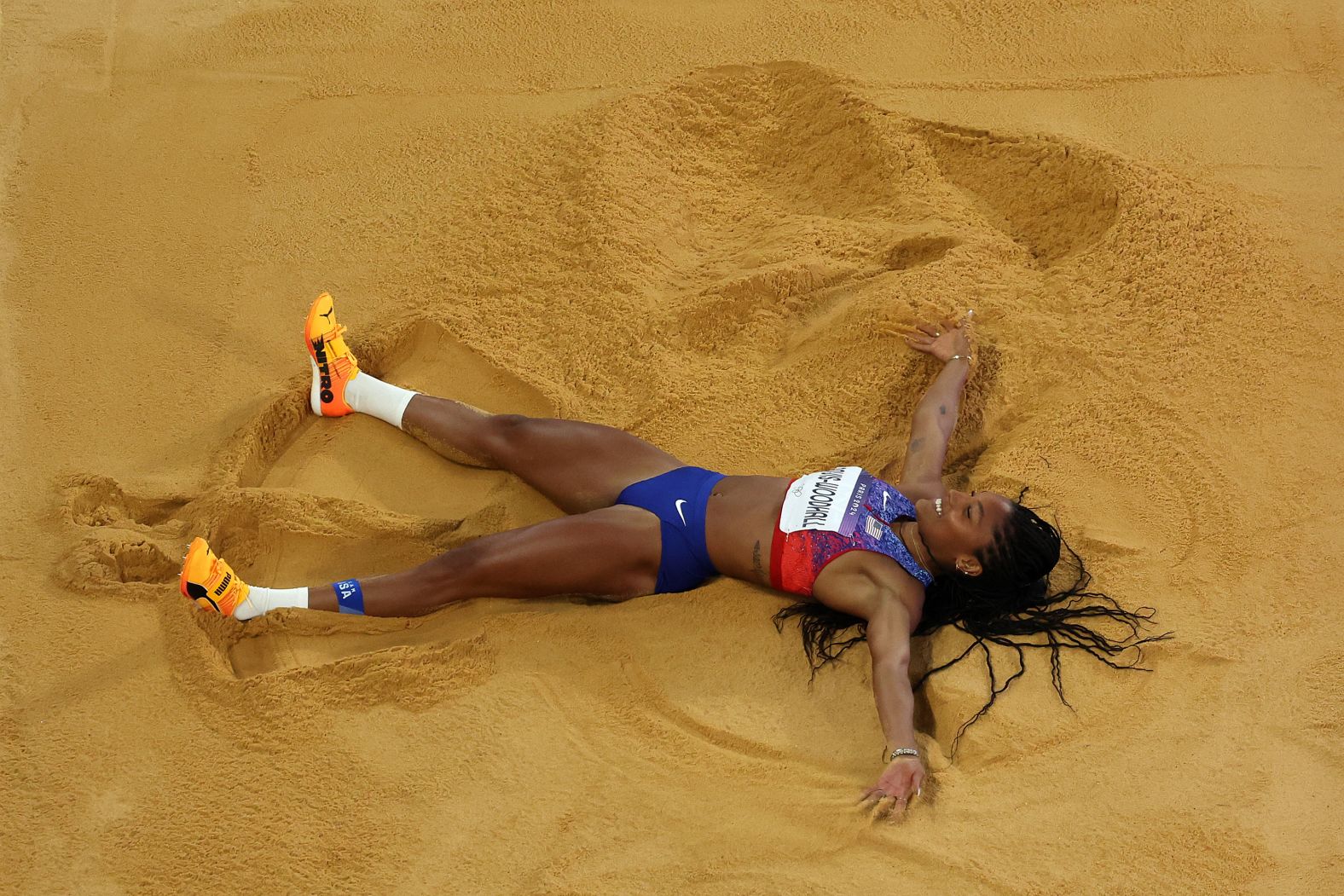 American long jumper Tara Davis-Woodhall celebrates in the sand <a href="https://www.cnn.com/sport/live-news/paris-olympics-news-2024-08-08#h_868d41b29914d80333e85fe5b69ae2b2">after winning gold</a> on August 8.