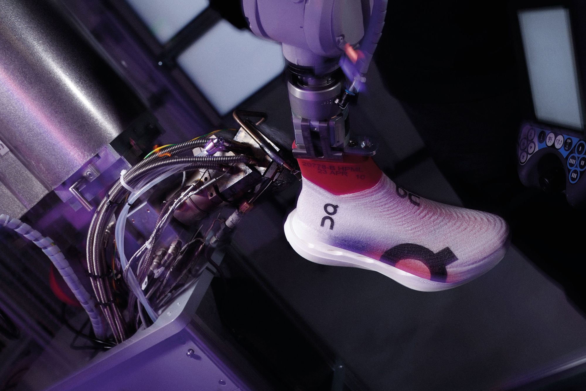 The shoes are sprayed using a robotic arm.