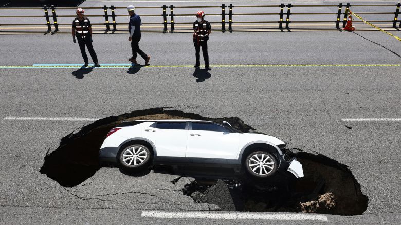 A vehicle that fell into a sinkhole is seen on a street in Seoul, South Korea, Thursday, Aug. 29, 2024. (Seo Dae-yeon/Yonhap via AP)