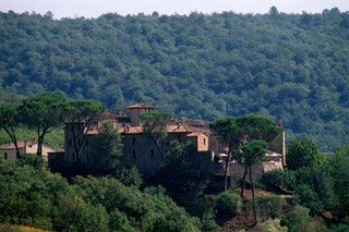 There's something rather medieval about arriving at this colossal hotel near Siena at night. After winding up to its...