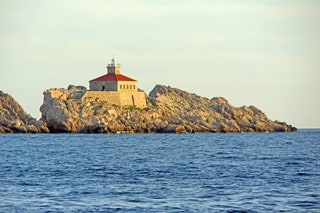 Built in 1872 Lighthouse Grebeni stands on a rugged rock populated only by yellowlegged gulls about a kilometre off the...